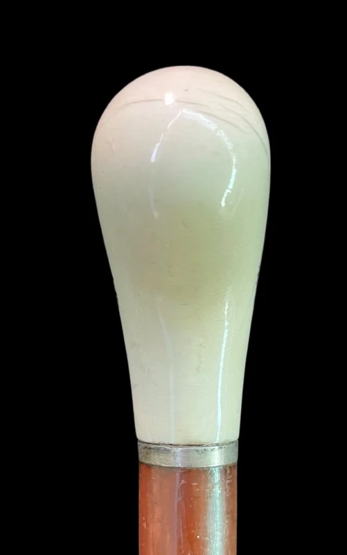 Cane with a spherical ivory knob on one side, engraved with a female figure