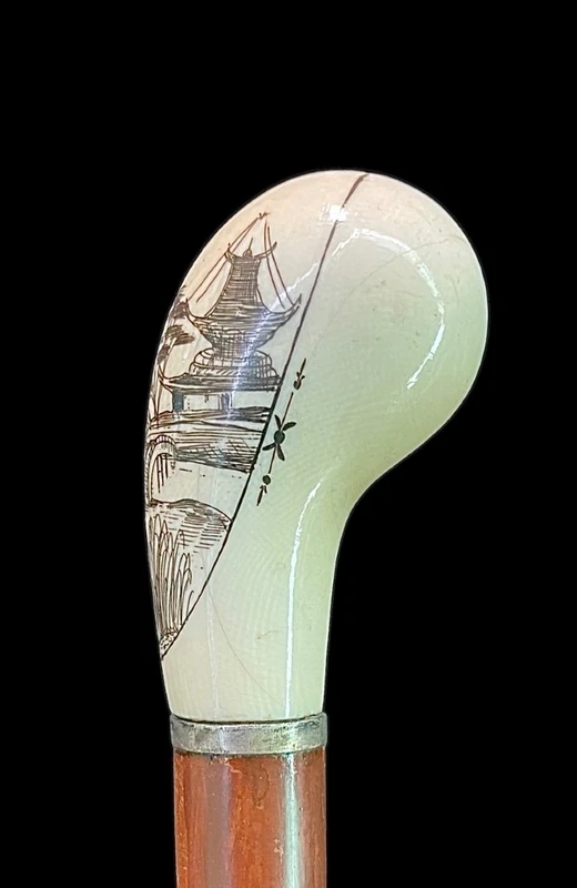 Cane with a spherical ivory knob on one side, engraved with a female figure