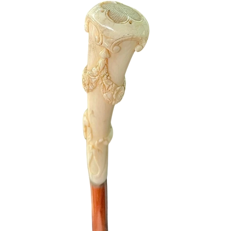 A walking stick with a vertical, curved ivory knob engraved with floral garlands and rocaille motifs.