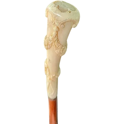 A walking stick with a vertical, curved ivory knob engraved with floral garlands and rocaille motifs.