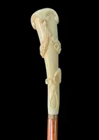A walking stick with a vertical, curved ivory knob engraved with floral garlands and rocaille motifs.