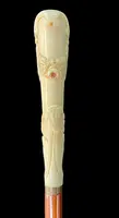 A walking stick with a vertical, curved ivory knob engraved with floral garlands and rocaille motifs.