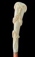 A walking stick with a vertical, curved ivory knob engraved with floral garlands and rocaille motifs.