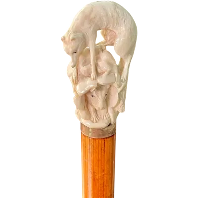 A walking stick with an ivory pommel depicting a wolf hunting prey hidden in a cave.