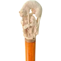 A walking stick with an ivory pommel depicting a wolf hunting prey hidden in a cave.