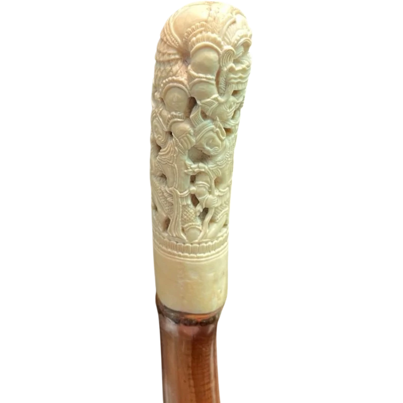 Cane with an ivory knob carved with figures and plant motifs; bamboo shaft.