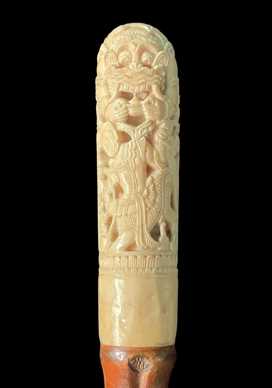 Cane with an ivory knob carved with figures and plant motifs; bamboo shaft.