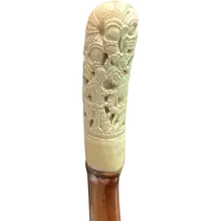 Cane with an ivory knob carved with figures and plant motifs; bamboo shaft.