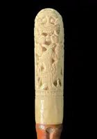 Cane with an ivory knob carved with figures and plant motifs; bamboo shaft.