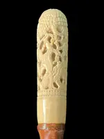 Cane with an ivory knob carved with figures and plant motifs; bamboo shaft.