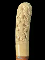 Cane with an ivory knob carved with figures and plant motifs; bamboo shaft.