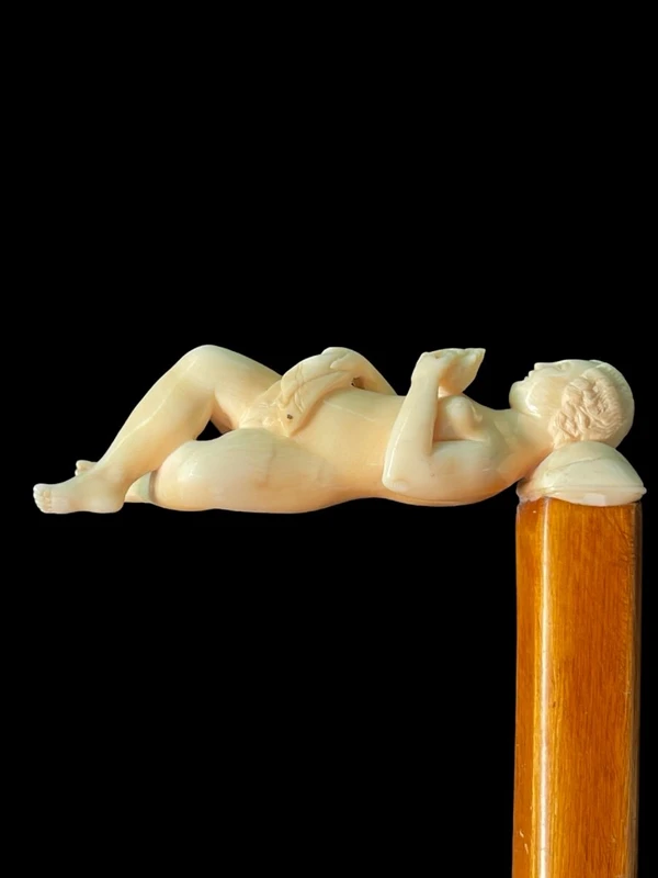 A walking stick with an ivory handle featuring an erotic motif of a reclining female figure.