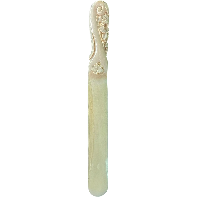A one-piece ivory letter opener engraved with floral and rocaille motifs.
