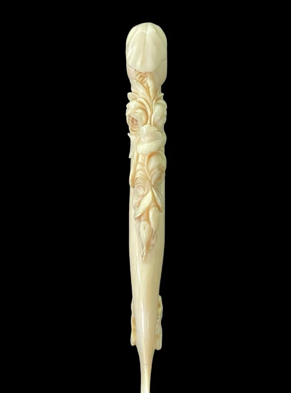 A one-piece ivory letter opener engraved with floral and rocaille motifs.
