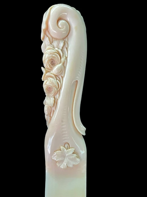 A one-piece ivory letter opener engraved with floral and rocaille motifs.