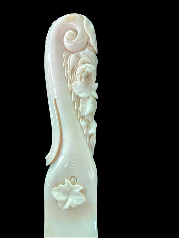 A one-piece ivory letter opener engraved with floral and rocaille motifs.