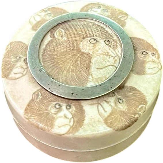A small ivory box with monkeys engraved on the lid.