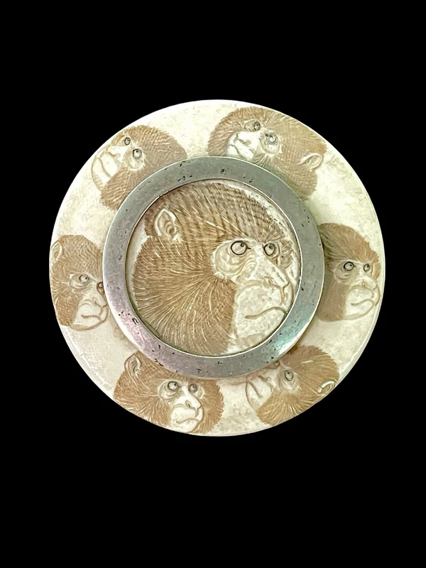 A small ivory box with monkeys engraved on the lid.