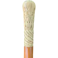 A walking stick with a spherical ivory pommel engraved with stylized plant motifs.