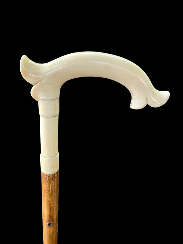 Cane with an ivory tau-shaped handle featuring a stylized rocaille motif.