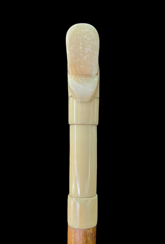 Cane with an ivory tau-shaped handle featuring a stylized rocaille motif.