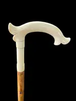 Cane with an ivory tau-shaped handle featuring a stylized rocaille motif.