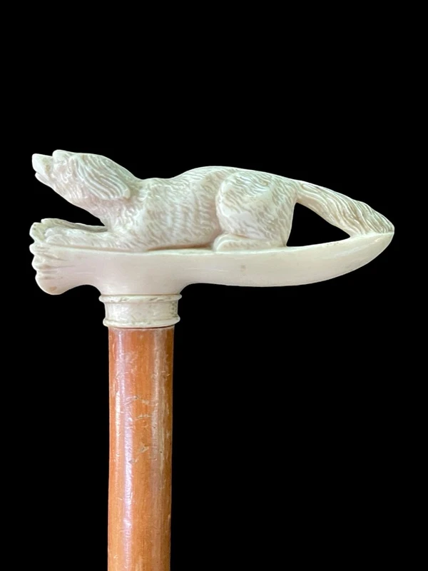 A walking stick with an ivory side handle depicting a dog hunting a hare.