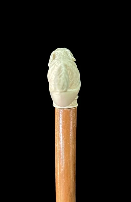 A walking stick with an ivory side handle depicting a dog hunting a hare.