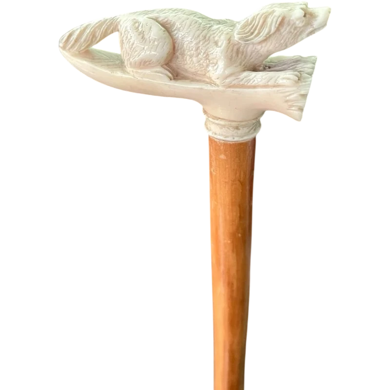 A walking stick with an ivory side handle depicting a dog hunting a hare.