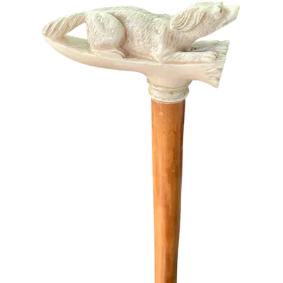 A walking stick with an ivory side handle depicting a dog hunting a hare.
