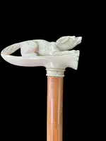 A walking stick with an ivory side handle depicting a dog hunting a hare.
