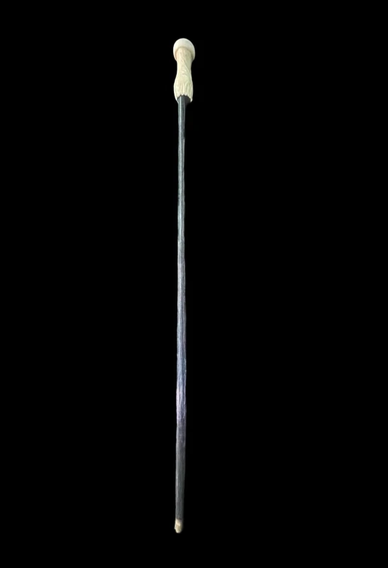 A walking stick with a spherical ivory pommel featuring a deer figure engraved in bas-relief.