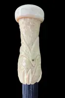 A walking stick with a spherical ivory pommel featuring a deer figure engraved in bas-relief.