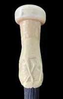 A walking stick with a spherical ivory pommel featuring a deer figure engraved in bas-relief.