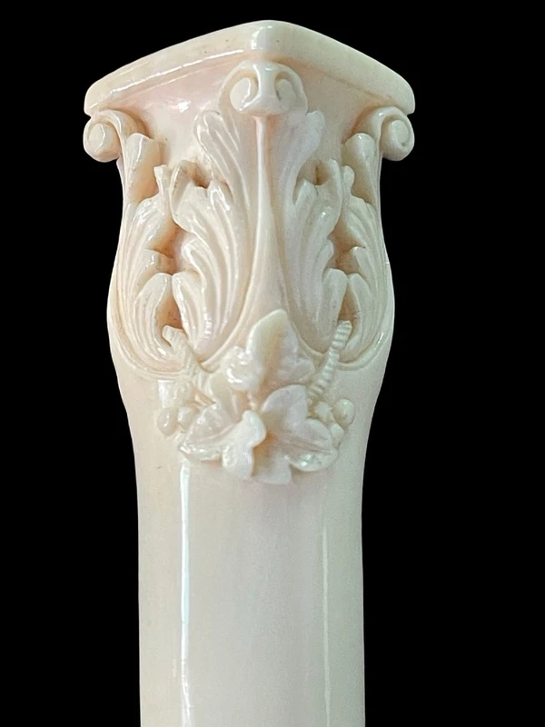 An evening cane with an ivory knob featuring a relief shield and rocaille motifs.