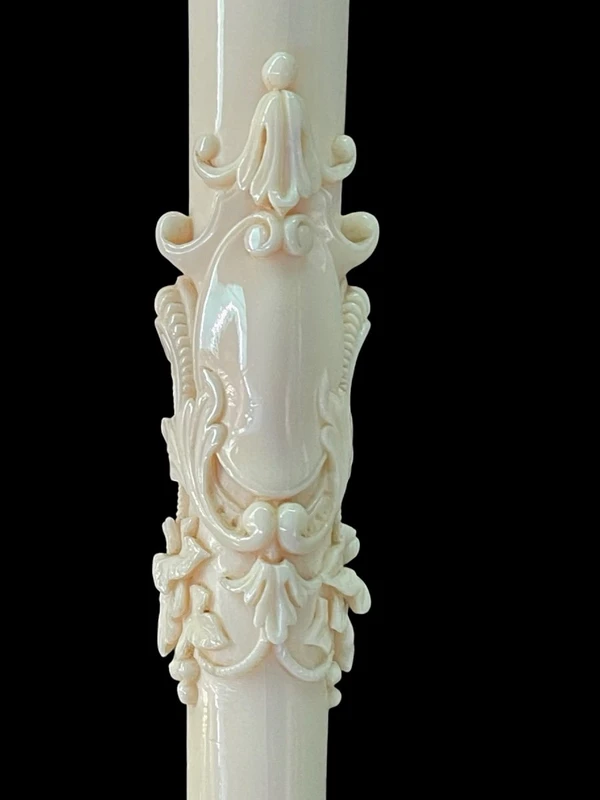 An evening cane with an ivory knob featuring a relief shield and rocaille motifs.