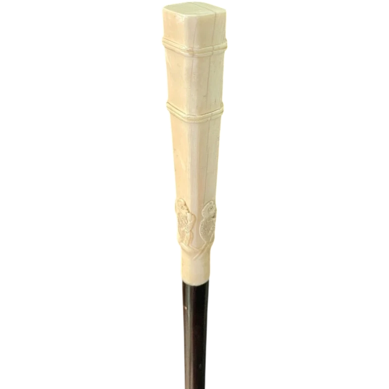 An evening cane with a square-section ivory knob featuring three monkeys engraved in bas-relief.