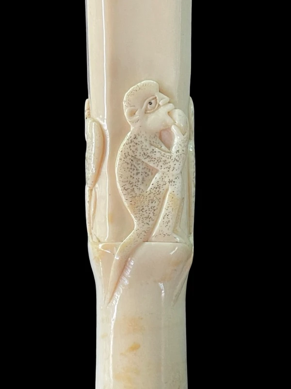 An evening cane with a square-section ivory knob featuring three monkeys engraved in bas-relief.