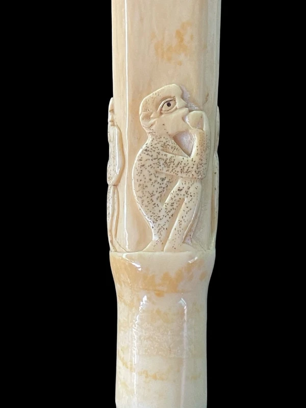 An evening cane with a square-section ivory knob featuring three monkeys engraved in bas-relief.