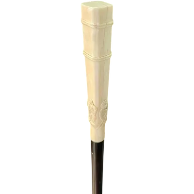 An evening cane with a square-section ivory knob featuring three monkeys engraved in bas-relief.
