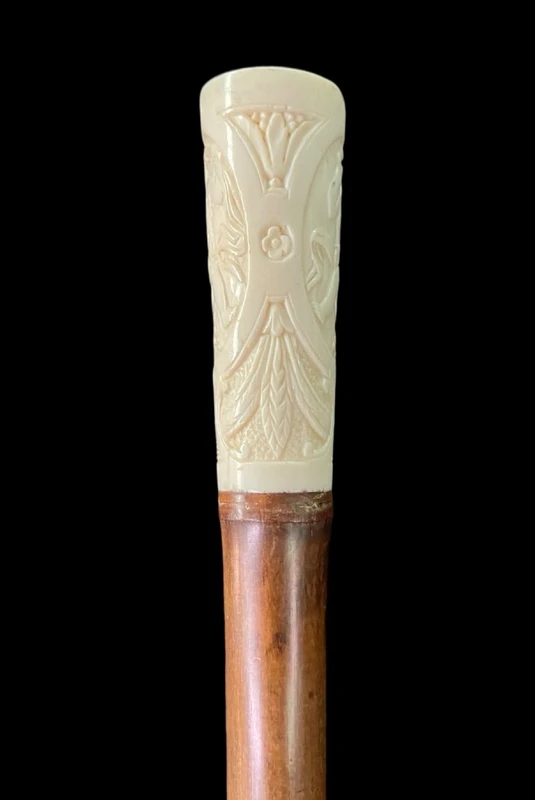 Cane with an ivory "plume" knob featuring cherubs engraved within three ovals