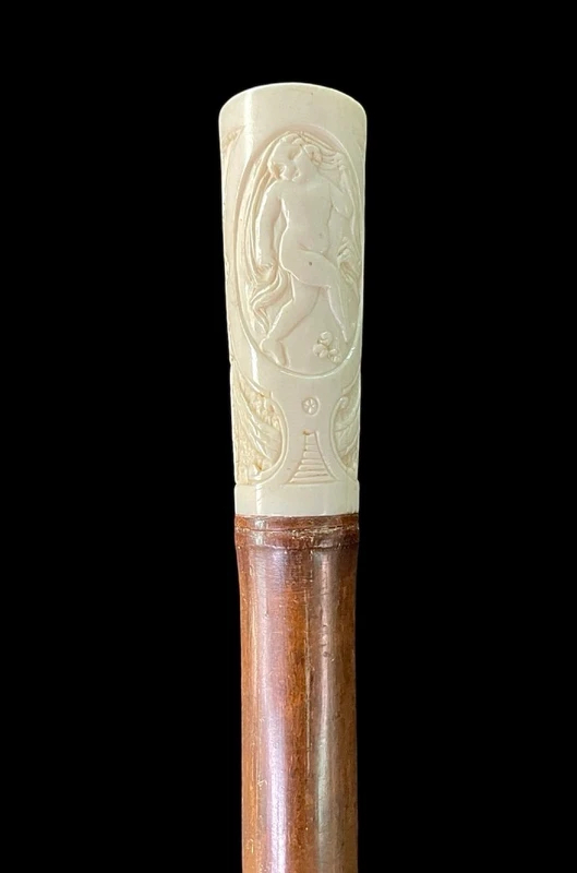 Cane with an ivory "plume" knob featuring cherubs engraved within three ovals