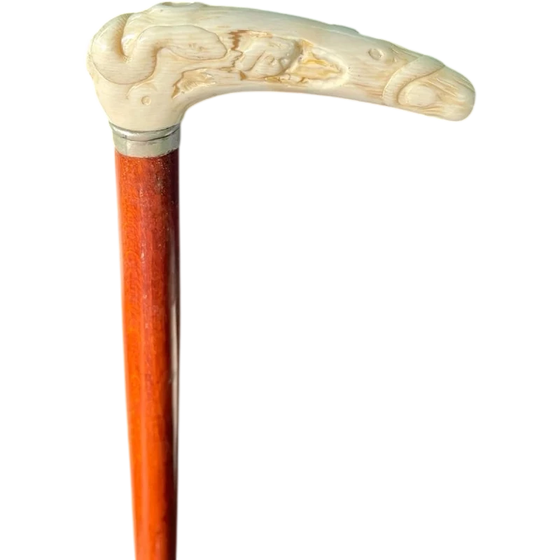 A staff with a side handle in the shape of a tau, made of ivory and depicting a snake hunting inside a tree trunk.