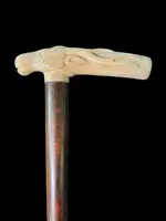 A walking stick with a side-mounted tau-shaped handle depicting a deer's head.