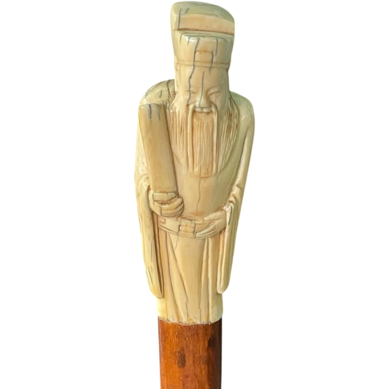 A walking stick with an ivory pommel depicting an Asian male figure.