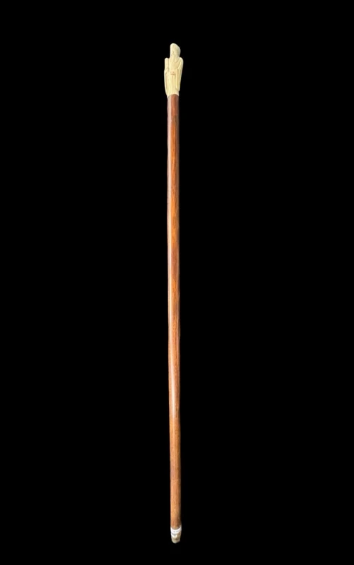 A walking stick with an ivory pommel depicting an Asian male figure.