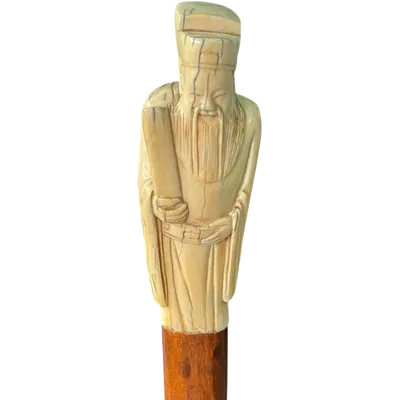 A walking stick with an ivory pommel depicting an Asian male figure.