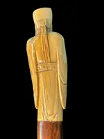 A walking stick with an ivory pommel depicting an Asian male figure.