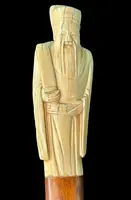 A walking stick with an ivory pommel depicting an Asian male figure.