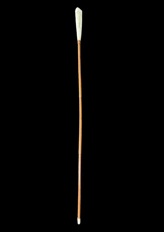 A walking stick with a "plume" knob featuring a high-relief figure of a child playing with a cat.